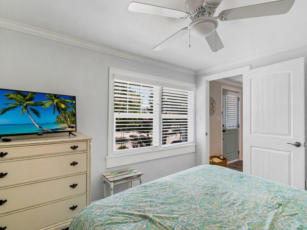 a bedroom with a bed and a ceiling fan