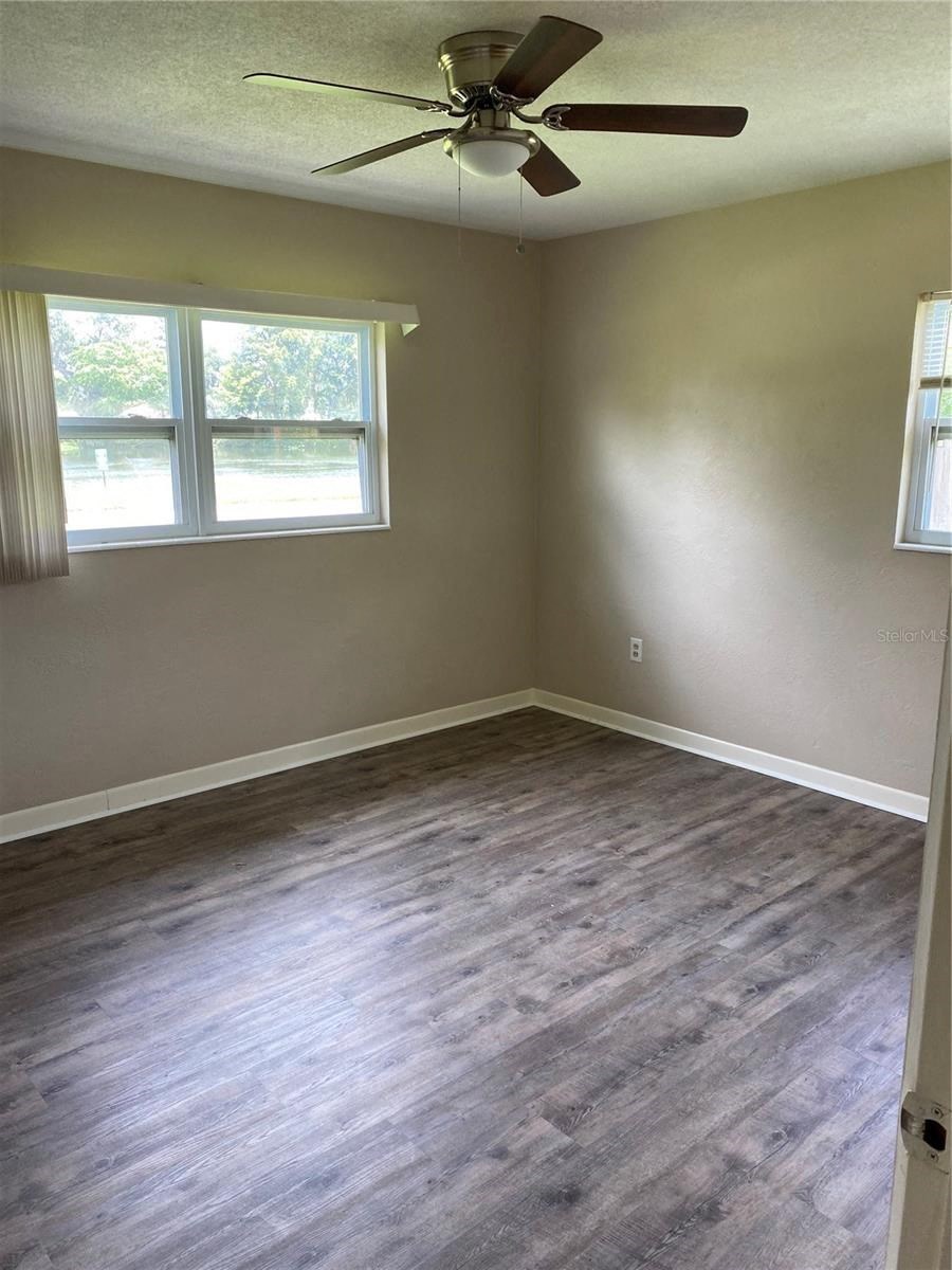 an empty room with wood floors and a ceiling fan