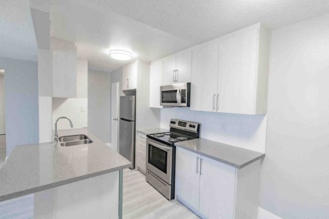 a kitchen with white cabinets and stainless steel appliances