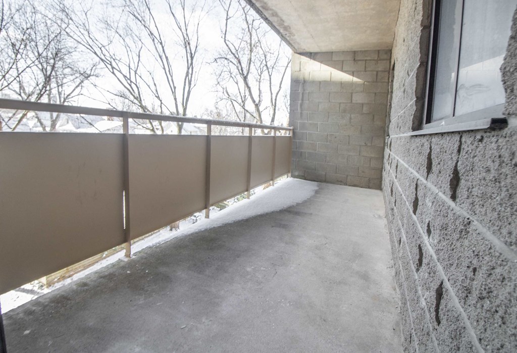 an empty balcony with a stone wall and a window