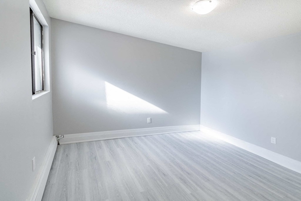 an empty room with white walls and a window