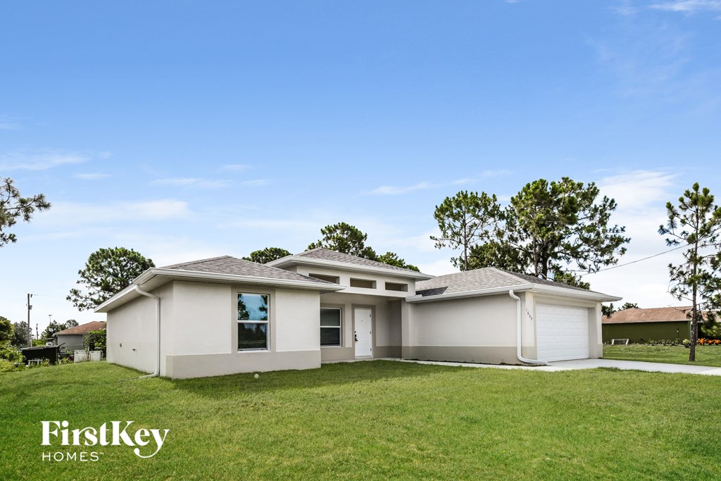 a white house with a yard and a blue sky