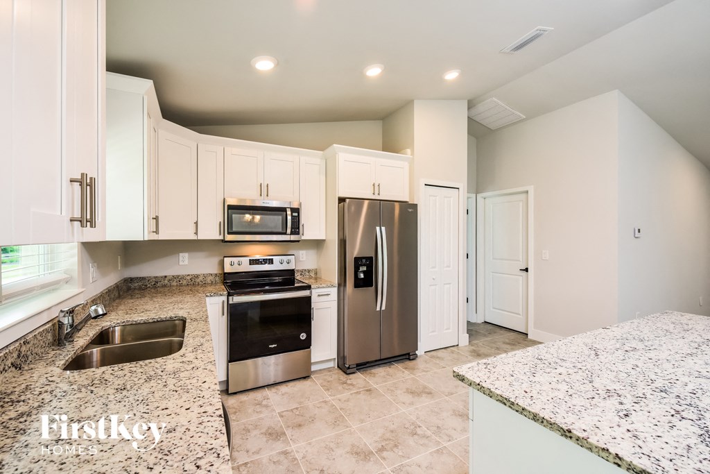 a kitchen with granite counter tops and stainless steel appliances
