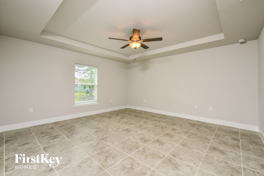 the living room of an empty house with a ceiling fan