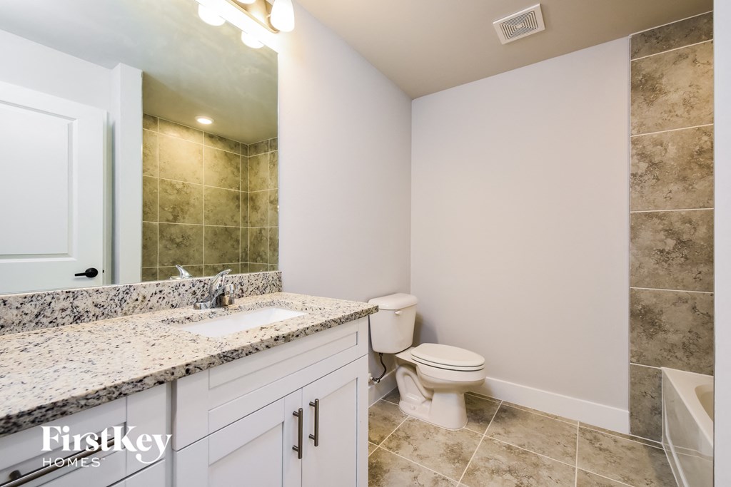 a bathroom with a toilet and a sink and a mirror