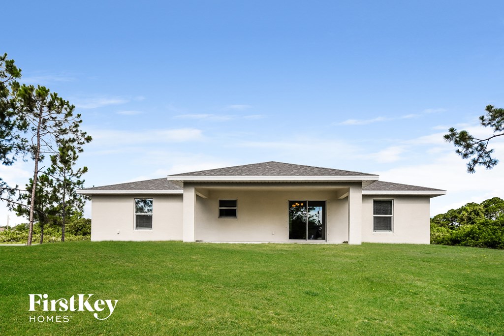 a white house with a green lawn and a blue sky