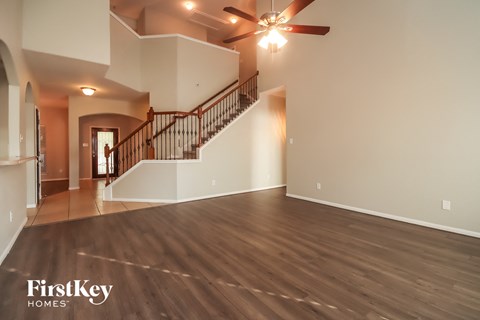 a living room with a staircase and a ceiling fan