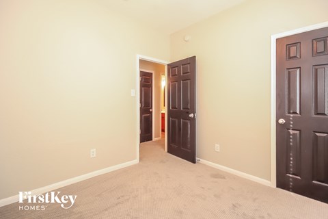 a bedroom with two doors and a carpeted floor