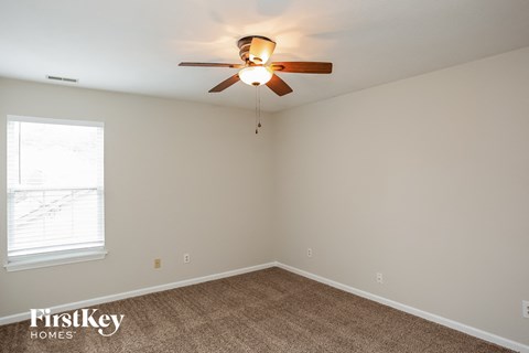 A room with a ceiling fan and a window.