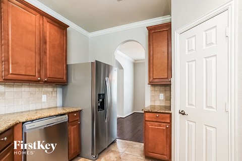 A kitchen with wooden cabinets and a stainless steel refrigerator.