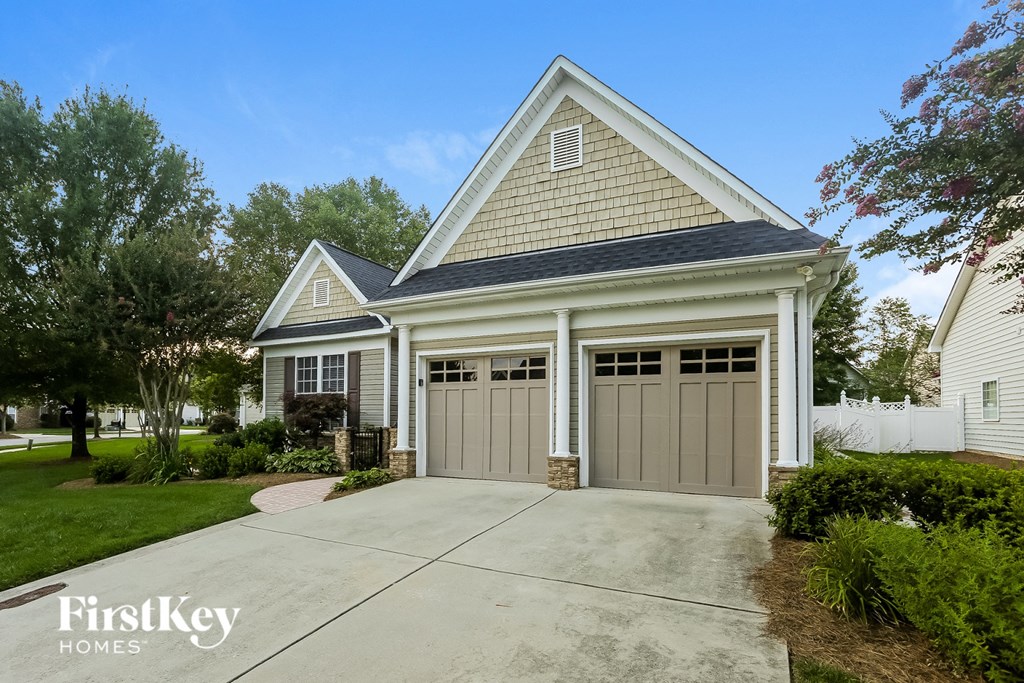 a home with two garage doors in front of a driveway