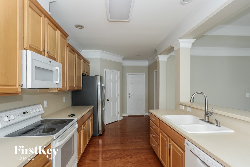 a kitchen with wooden cabinets and white appliances and a sink