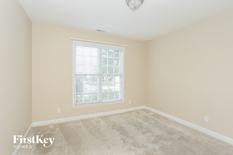 a spacious living room with carpet and a window
