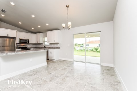 a kitchen with white cabinets and a door to a patio