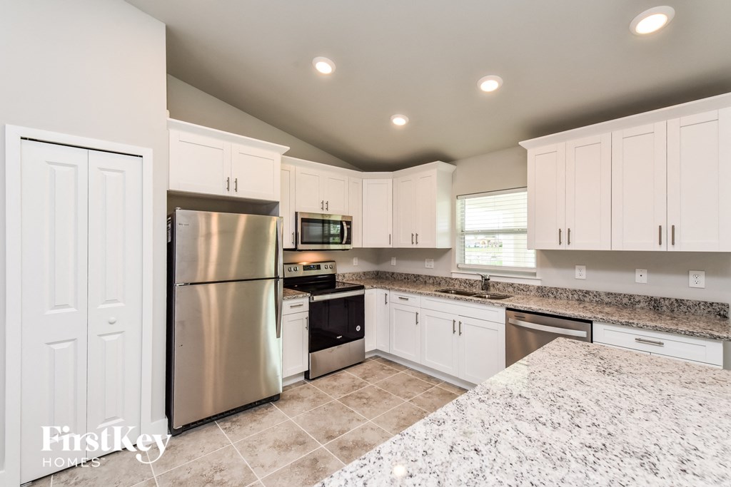 a kitchen with white cabinets and stainless steel appliances