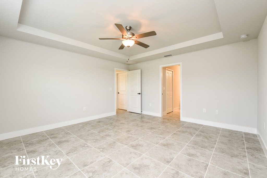 the spacious living room with ceiling fan and tile flooring