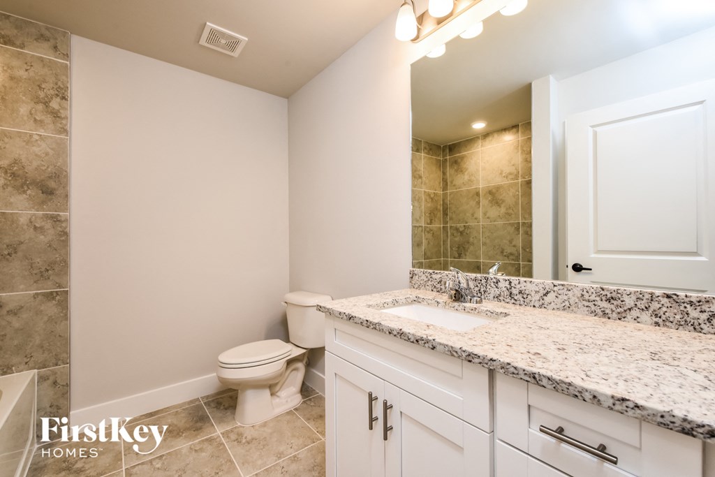a bathroom with a toilet and a sink and a mirror