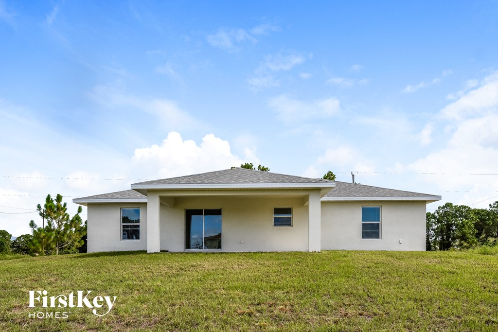 a white house on a hill with a blue sky