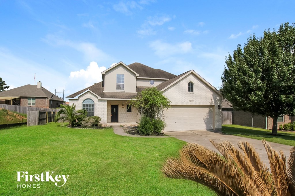A large house with a well-maintained lawn and a clear blue sky above.