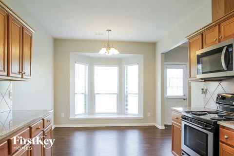 A kitchen with wooden cabinets and a stove top oven.