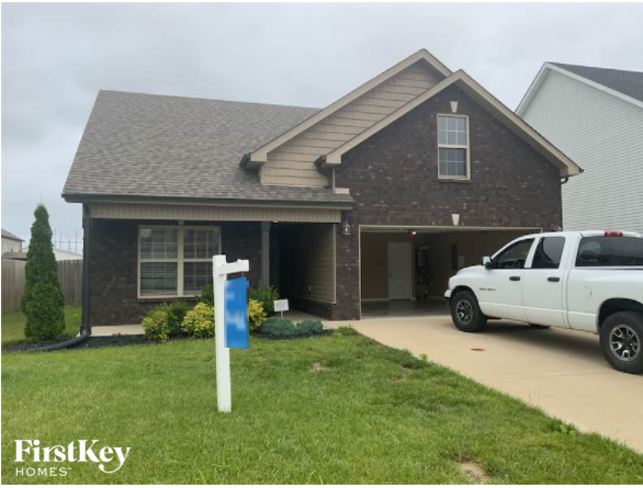 A house with a white pickup truck parked in front.