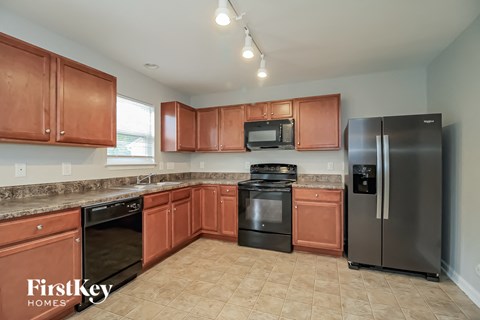 A kitchen with brown cabinets and black appliances.
