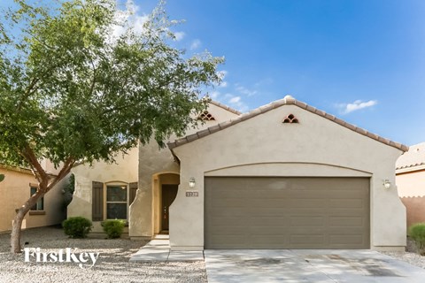 a house with a garage door and a tree