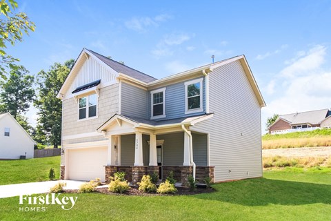 A house with a garage and a covered porch is for sale.