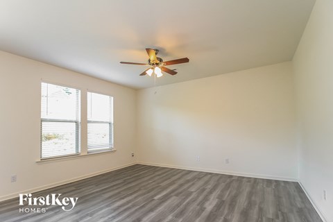A room with a ceiling fan and a window.