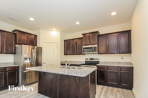 A kitchen with brown cabinets and a granite countertop.
