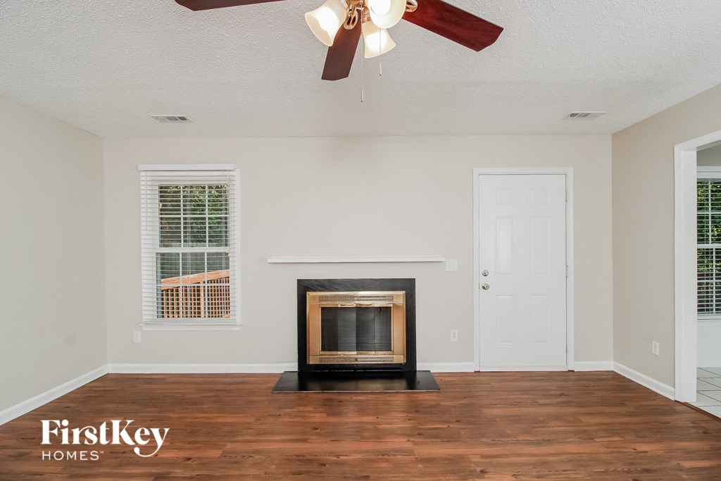 a living room with a fireplace and a ceiling fan