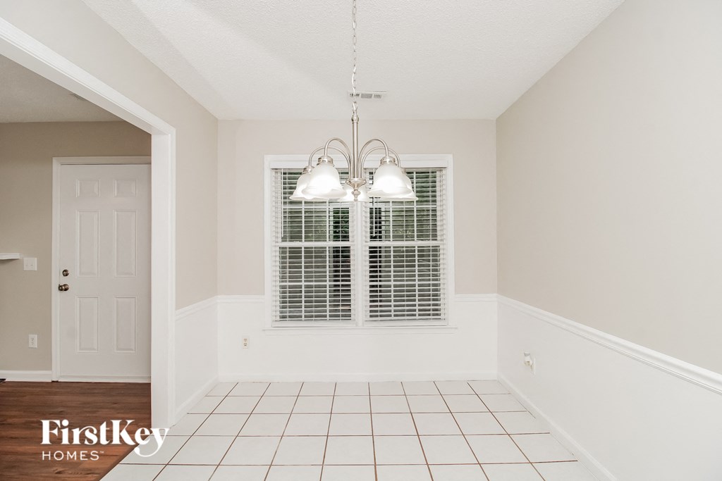 a dining room with two windows and a white tiled floor