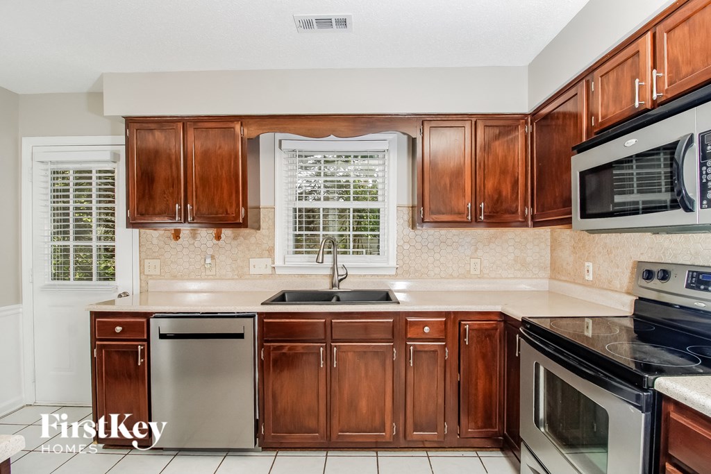 a kitchen with wooden cabinets and stainless steel appliances