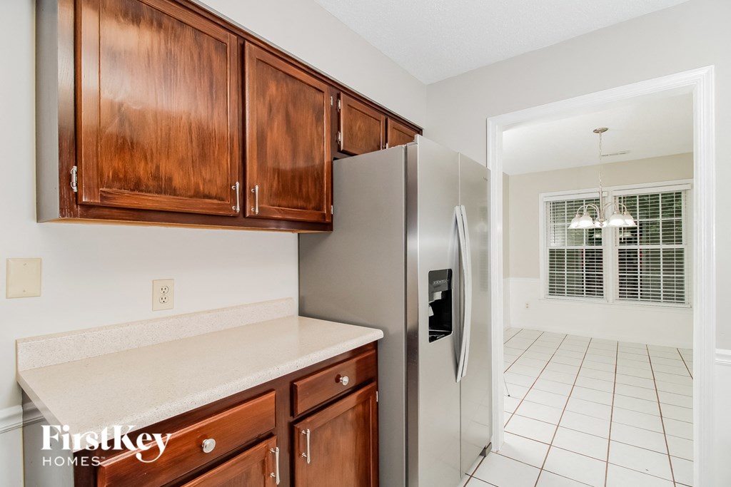a kitchen with wooden cabinets and a stainless steel refrigerator