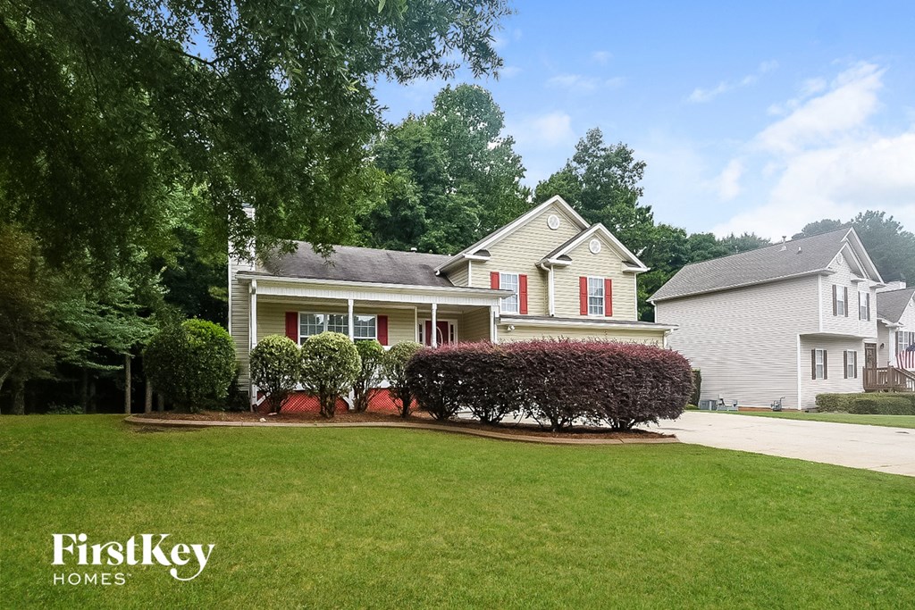 A house with a lawn and trees in front of it.