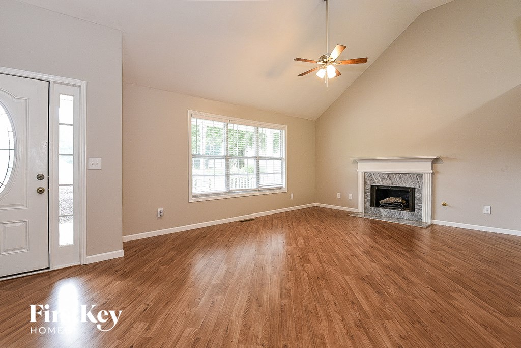 A room with a fireplace and a ceiling fan.