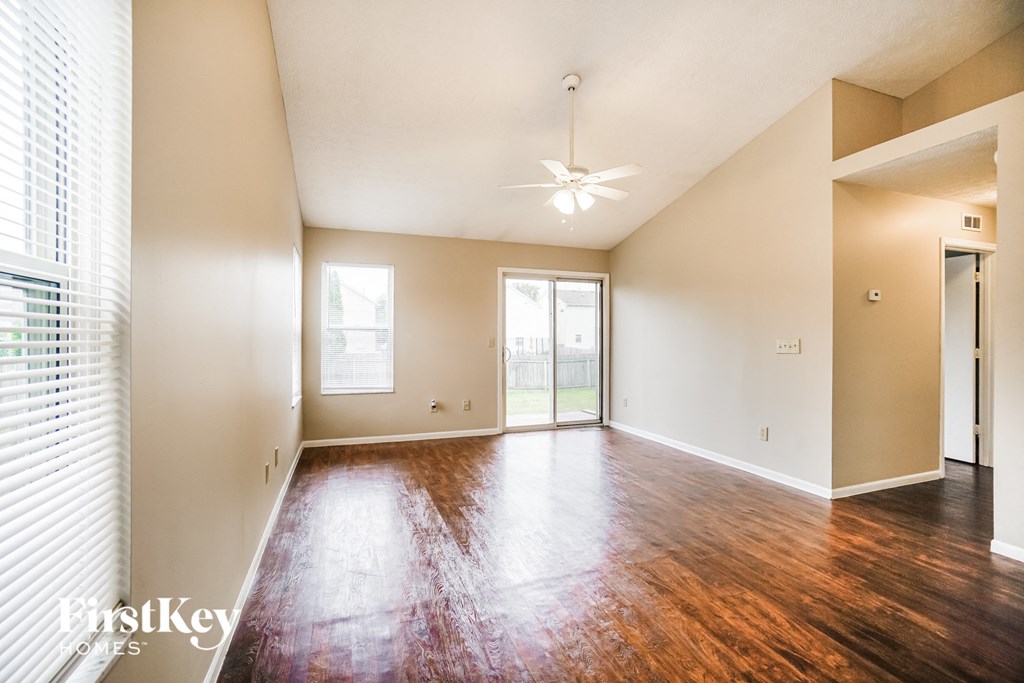 the living room and dining room of an empty house with wood flooring