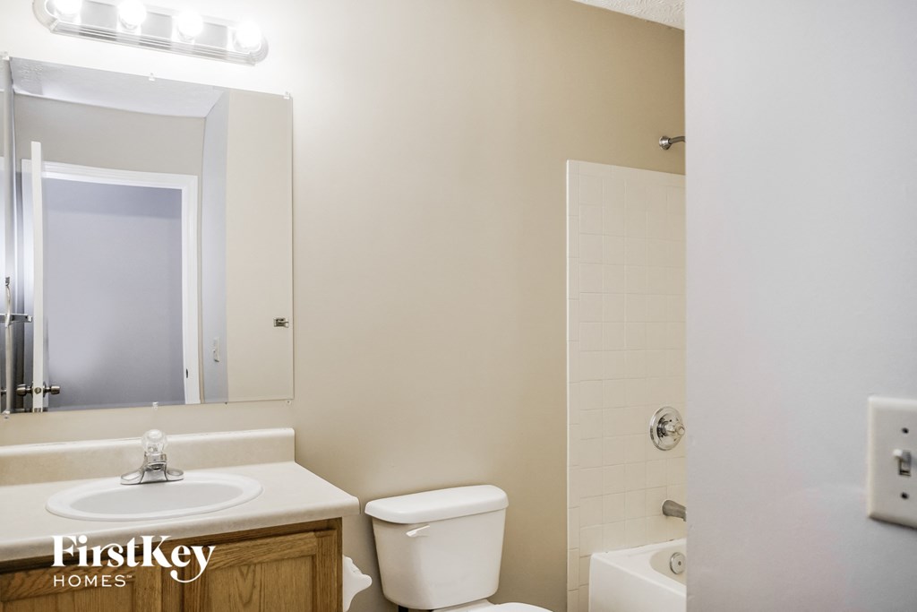 a bathroom with a toilet and a sink and a mirror