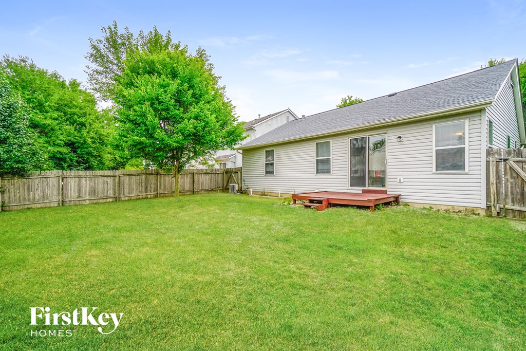 a backyard with a deck and a house