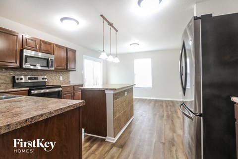 A kitchen with wooden cabinets and a granite countertop.