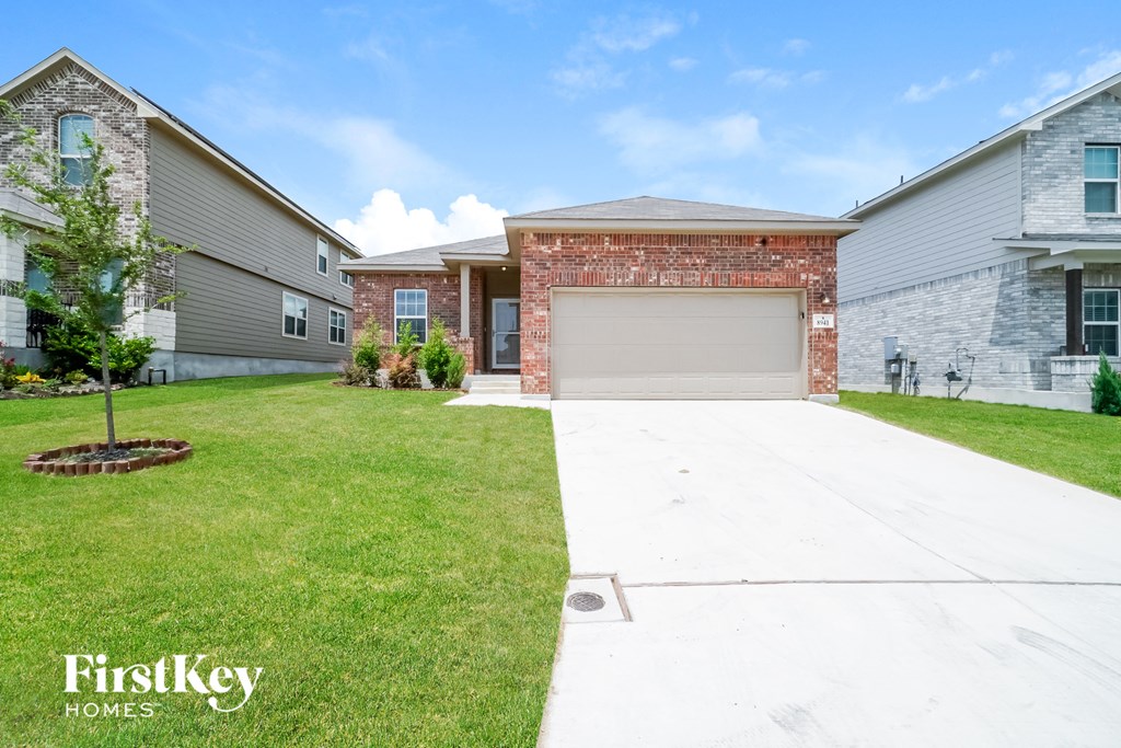 a white driveway in front of a brick house with a garage door