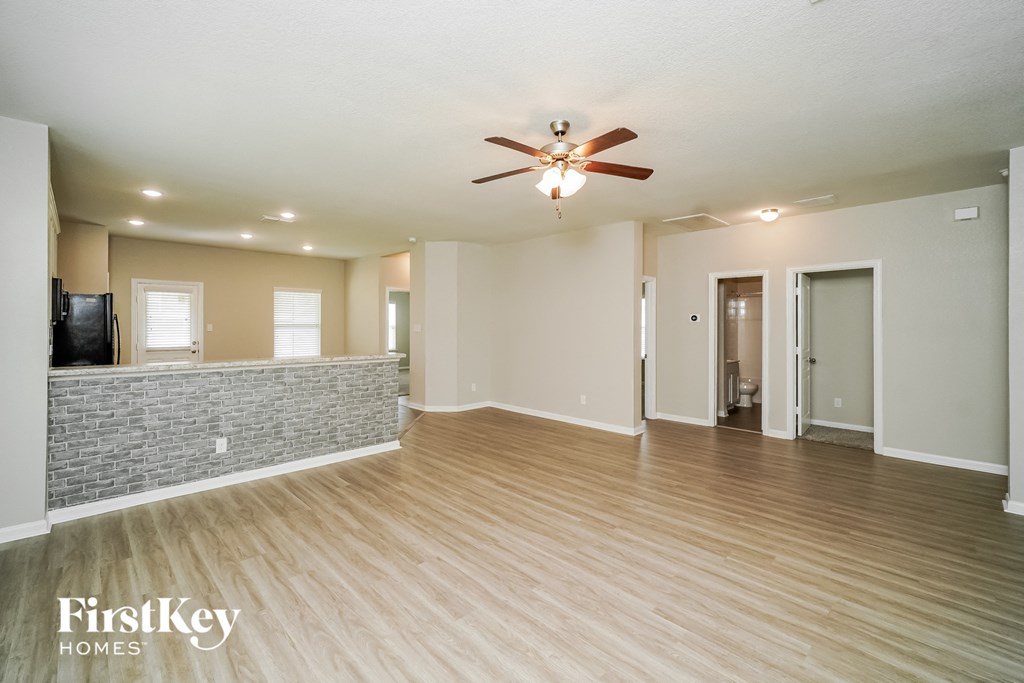 an empty living room with a ceiling fan