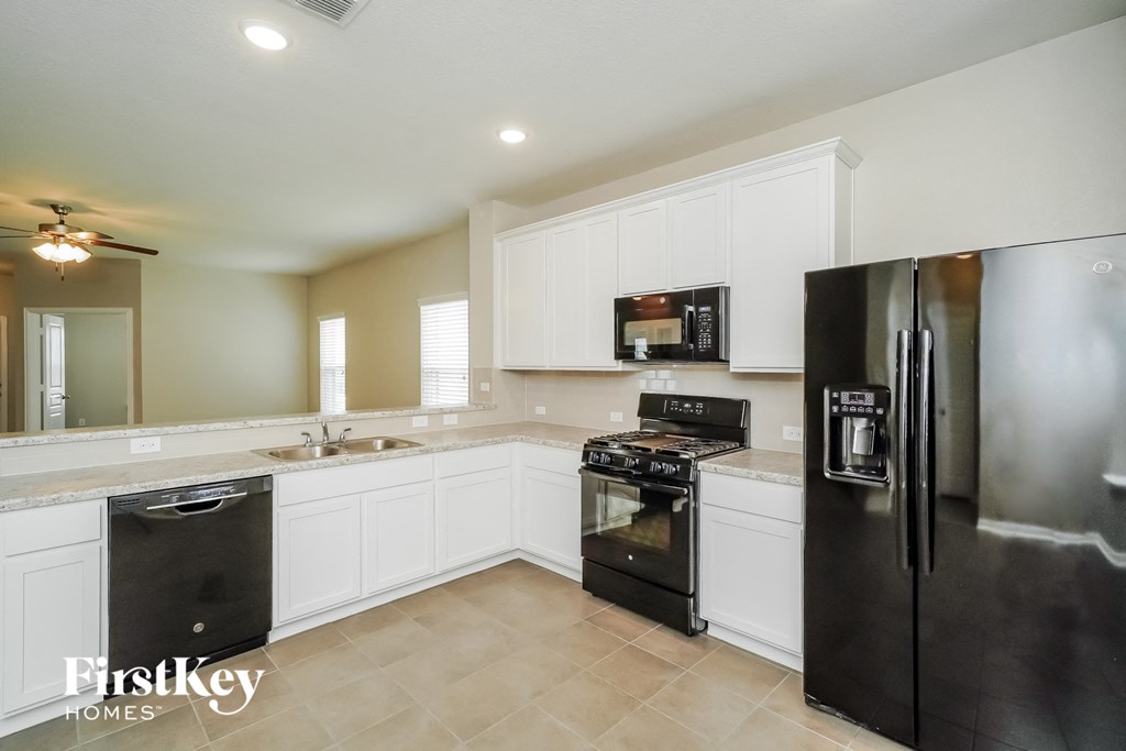 a kitchen with white cabinets and stainless steel appliances