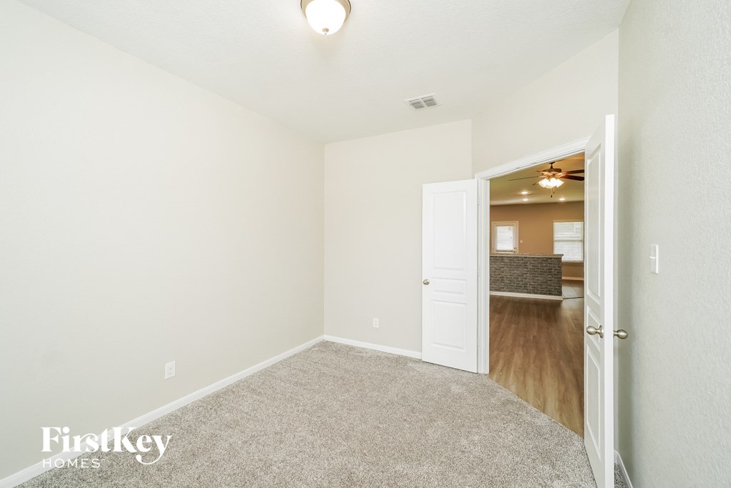 a spacious living room with white walls and wood flooring