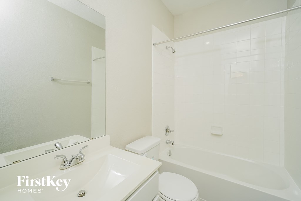 a white bathroom with a sink toilet and tub