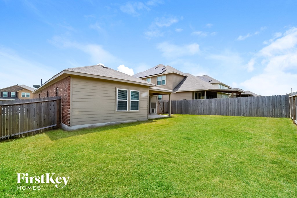 the backyard of a house with a yard and a fence