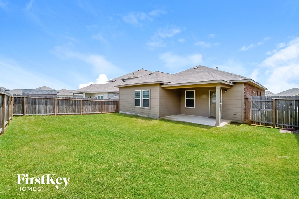 the backyard of a house with a yard and a fence