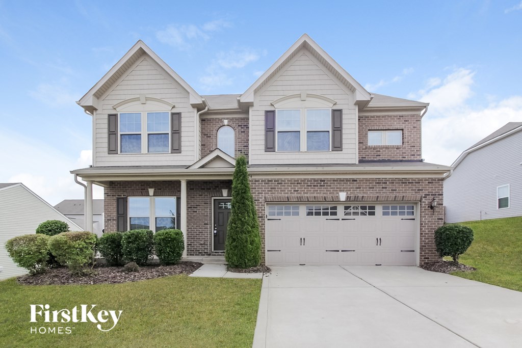 a house with a white garage door in front of a lawn