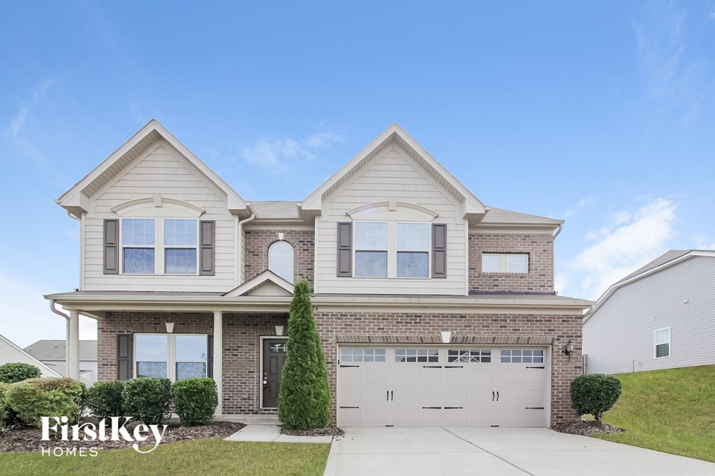 a home with a white garage door and a brick house