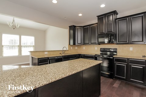 a kitchen with black cabinets and a granite counter top